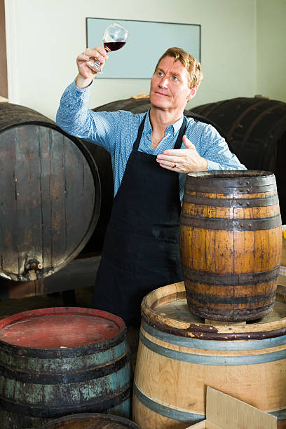 istock man with glass of wine in wine cellar 619372342