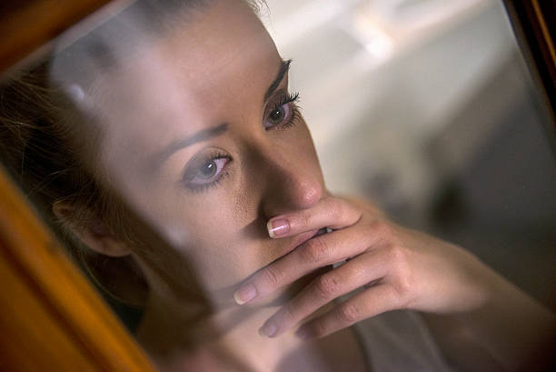 istock Looking through the window. Thoughtful young women looking 619373016