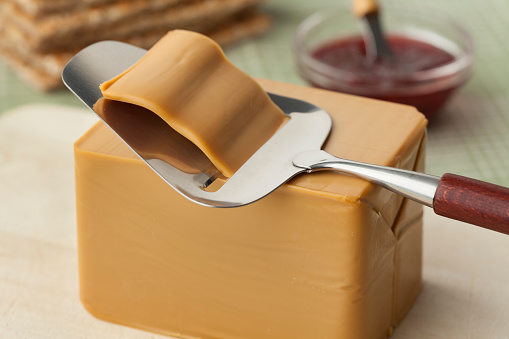 Piece of norwegian flotemysost cheese and a slicer
