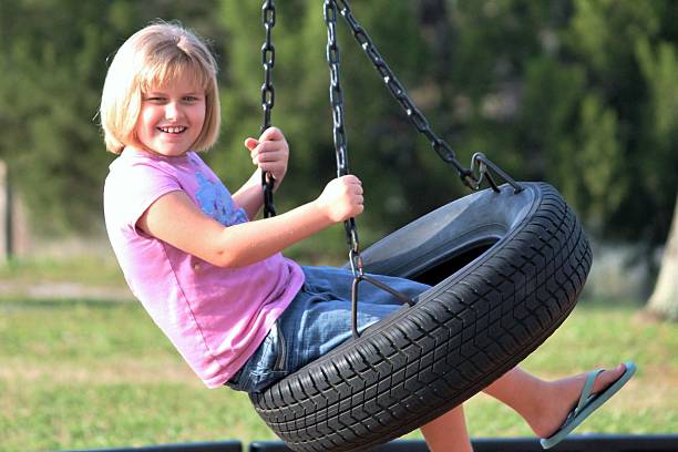 istock Child in a Tire Swing 619374376