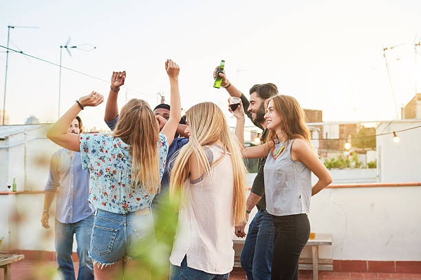 istock Large group of friends dancing and celebrating a rooftop party. 619374504
