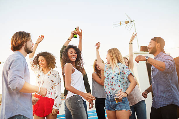 istock Large group of friends dancing and celebrating a rooftop party. 619374580