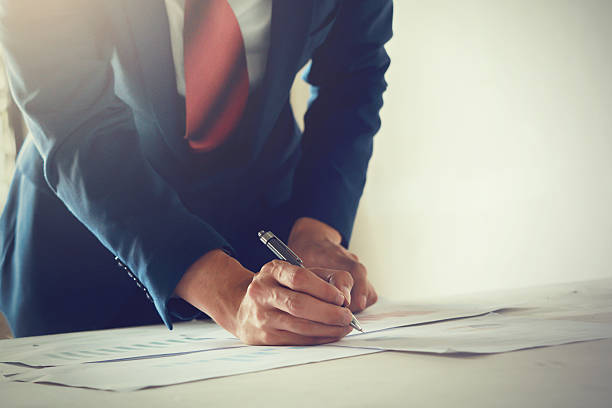 istock Businessman in suit writing on work desk - vintage tone 619375076