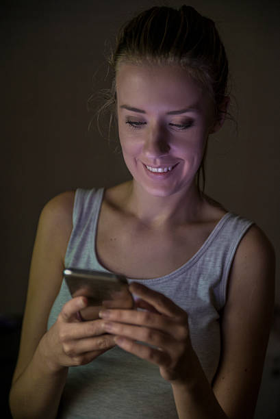 istock Smiling girl using smartphone  at night 619375318