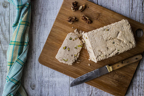 istock Halva Slice with peanut and walnut on a wooden surface. 619376042