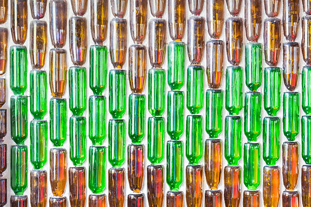 istock Green and brown glass bottles glued on the wall. 619376202