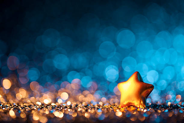 Star ornament on defocused warm and cold background lights.