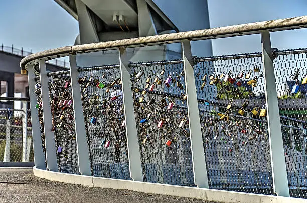 Colorful locks attached to the railing of a modern bridge across Rijnhaven in Rotterdam