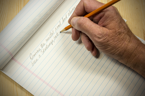 An author beginning his manuscript with pencil and pad- beginning sentence is shown.