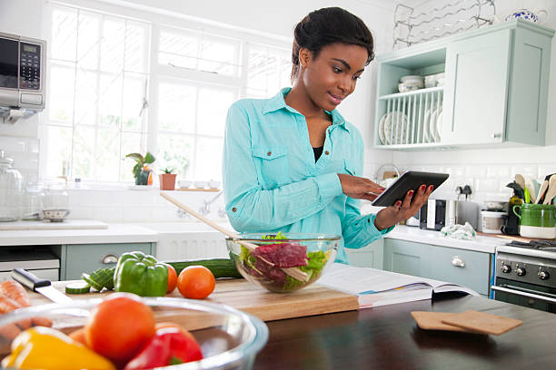 African woman reading a recipe. stock photo
