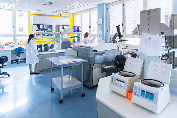 three cute technicians in laboratory of blood bank - santrifüj stok fotoğraflar ve resimler