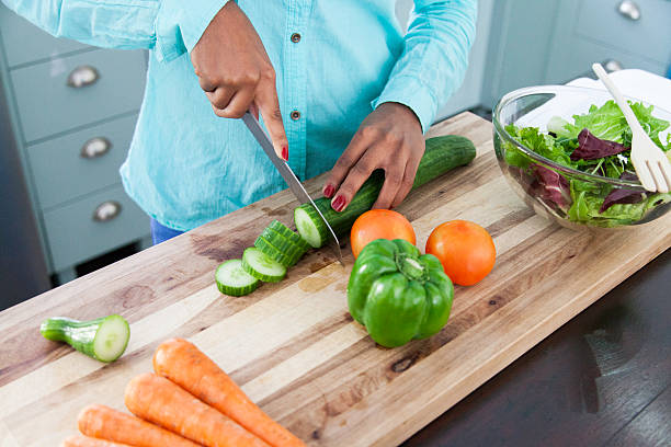 istock African female chopping a cucumber. 619388640
