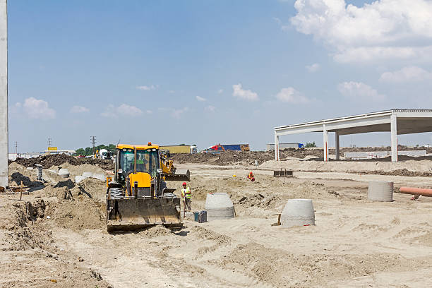 Excavator is working on construction site. Zrenjanin, Vojvodina, Serbia - June 4, 2015: View on excavator at construction site in the large complex shopping mall "AVIV PARK" in Zrenjanin city. construction site building contractor occupation front end loader stock pictures, royalty-free photos & images