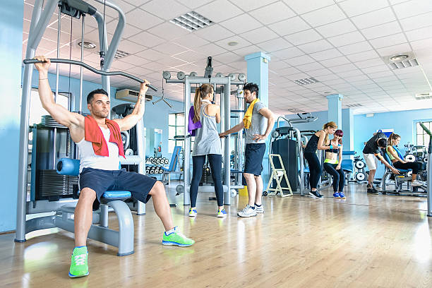 grupo de amigos deportivos en el gimnasio gimnasio gimnasio club center studio - gym machine smiling coach fotografías e imágenes de stock