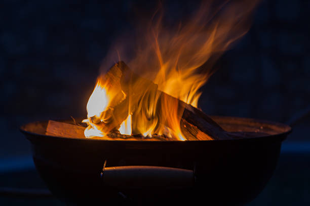 istock Firewood burning in grill bowl at night 619391688