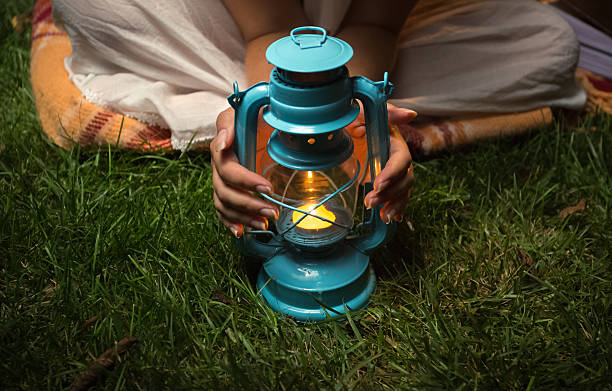 istock Woman warming hands on lantern at garden at night 619391708