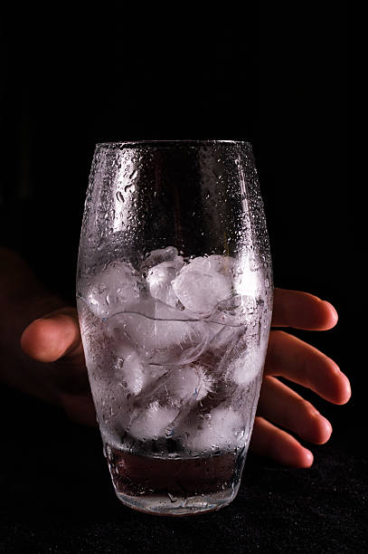 Hand holding glass with water and ice