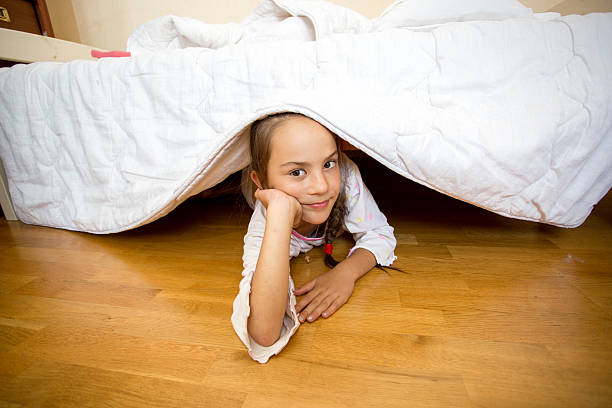 istock little girl lying on floor under bed 619392806