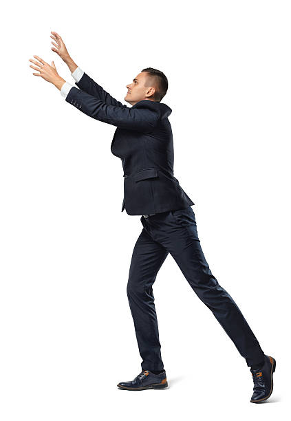 Businessman in profile with his leg set back and hands