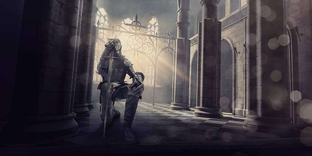 Medieval Knight in Armour Kneeling With Sword Inside Castle A medieval knight in full suit of armour kneels whilst holding his sword to his head in contemplation or prayer before a big battle. The knight is inside an ancient medieval stone building, which could be a castle or cathedral as the evening from the setting sun streams through the windows. knight person photos stock pictures, royalty-free photos & images