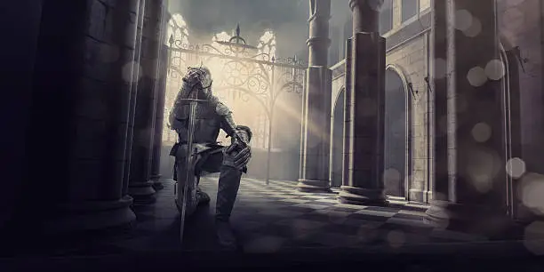 Photo of Medieval Knight in Armour Kneeling With Sword Inside Castle