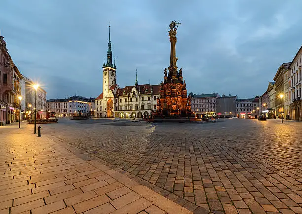 Town hall and Holy Trinity Column in the main square of the old town of Olomouc, Czech Republic after sunset.