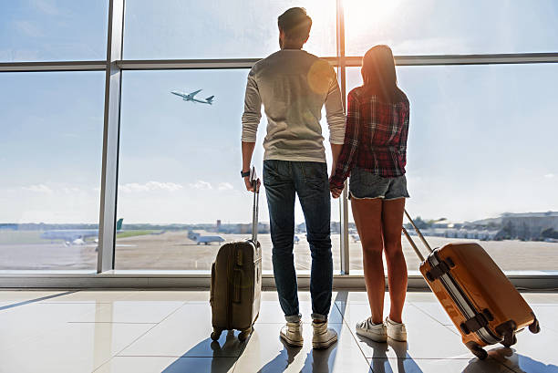 istock Dreamful loving couple looking at flying plane 619395870