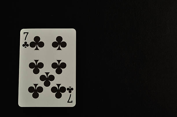 istock Playing card. Seven of clovers isolated on a black background 619396334