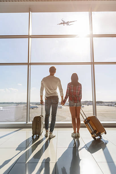 istock Young man and woman watching aircraft flight 619396396