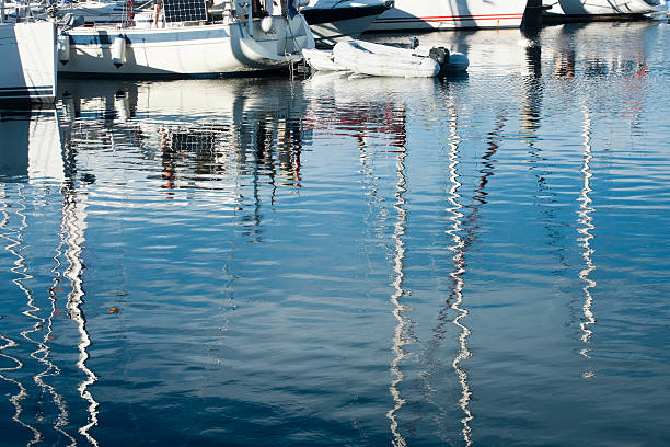 istock Sailboats, masts and clear blue sky reflection. 619397118