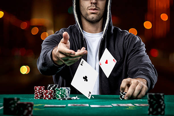 Poker player Poker player showing a pair of aces, on a bokeh lights background. texas hold em photos stock pictures, royalty-free photos & images