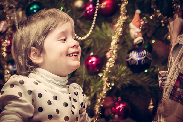 istock Happy smiling child getting Christmas gift with Christmas tree 619398278