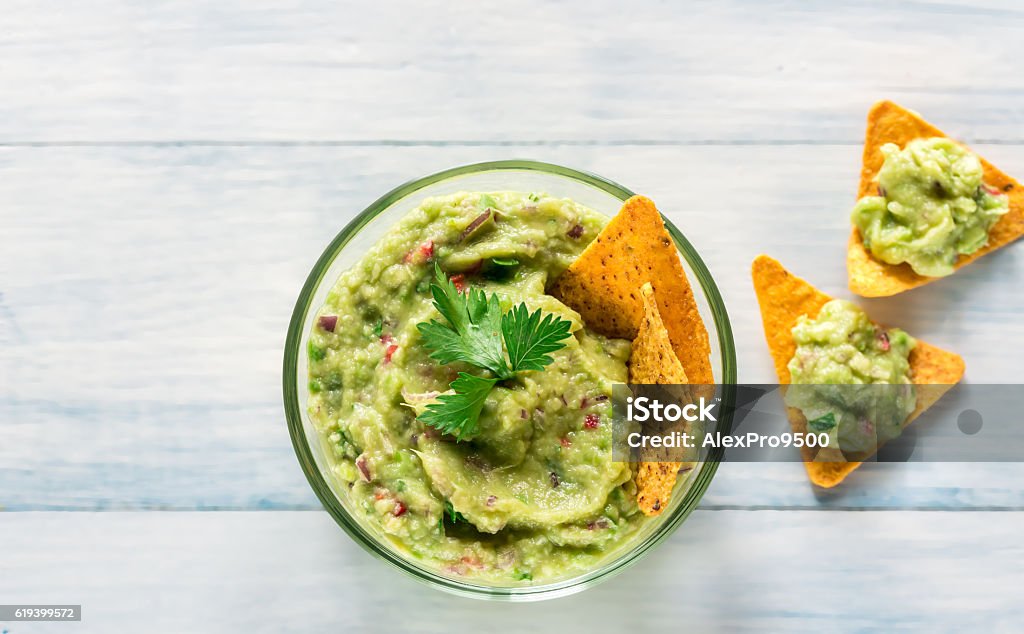 Tigela de guacamole com chips de tortilla - Foto de stock de Guacamole royalty-free