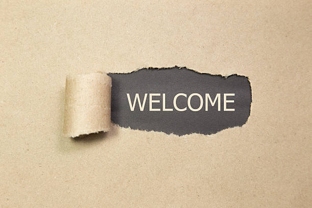 istock The text WELCOME behind torn brown paper 619401282