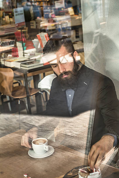 istock Stylish Hipster in a book-cafe with coffee or cappuccino 619401410