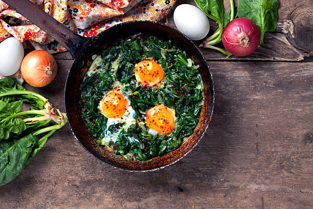 古いフライパンでほうれん草と卵を煮込む - omelet breakfast eggs onion ストックフォトと画像