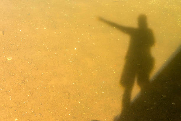 Shadow Silhouette of a Man Standing over Water Pointing 