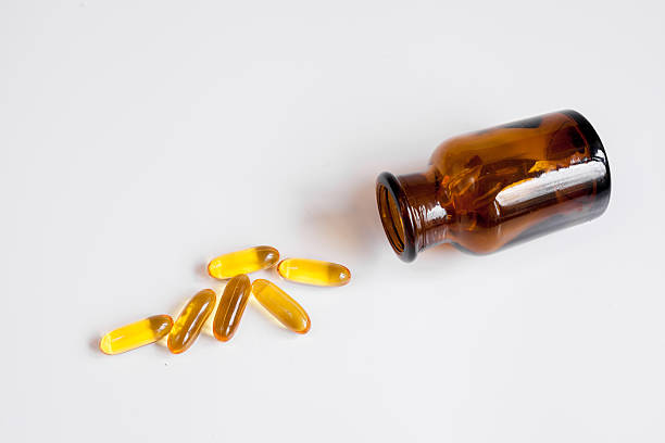istock fish oil pills glass bottle on white background top view 619403084