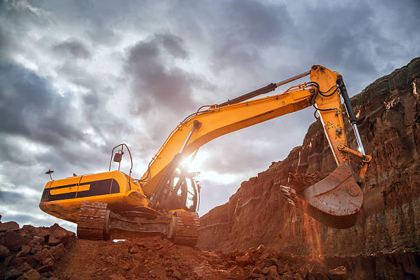 Earthworks with dramatic sky Excavator digging in red soil earthwork stock pictures, royalty-free photos & images