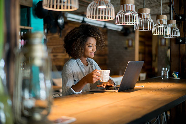 mulher trabalhando online em um café - owner small business restaurant african ethnicity - fotografias e filmes do acervo