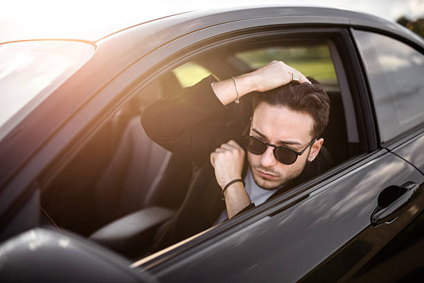 istock fashion man driving a black car 619405914