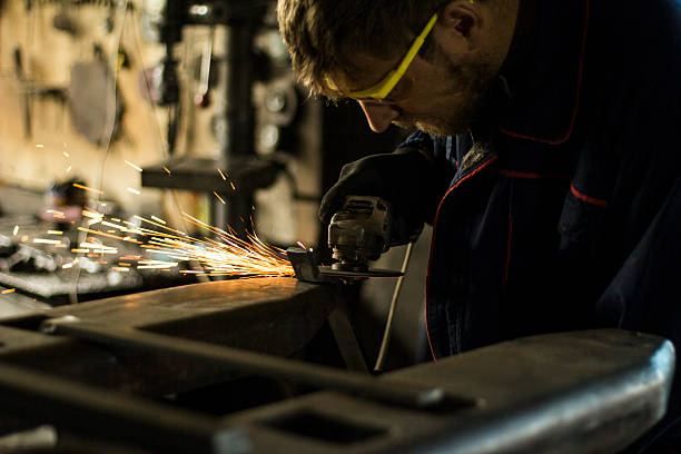 istock Worker grinding a metal part in his workshop. 619407450
