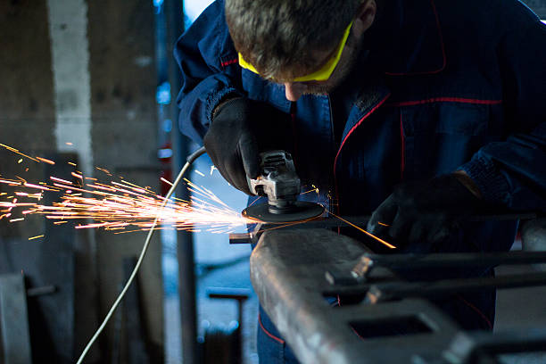 istock Worker grinding a metal part in his workshop. 619407578