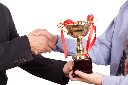 Asian business man shake hand and receive golden trophy on white background