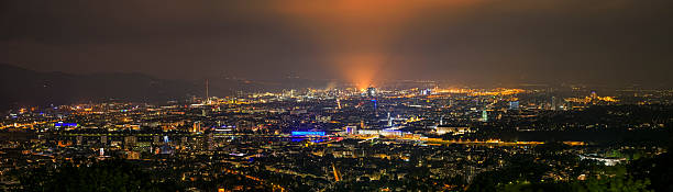 Cityscape of Linz, Austria at night Panorama - Cityscape of Linz, Austria at night. Bright light from the steelworks. In the foreground the Danube with old town and in the background the industrial area with steelworks. linz austria stock pictures, royalty-free photos & images