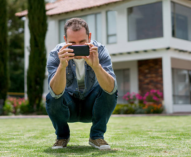 Casual man outdoors taking a picture with his cell phone - lifestyle concepts