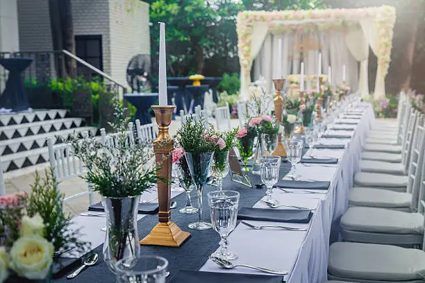 glass of vase with beautiful flowers with dining set  at a Wedding Reception