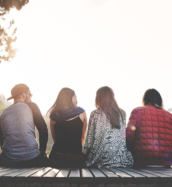 istock Friends Sitting in a Row Outdoors Concept 619413264