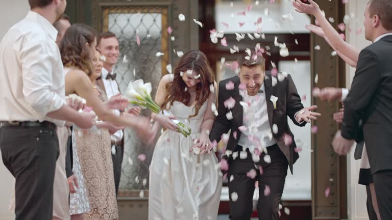 SLO MO Newlyweds being showered with petals when leaving church