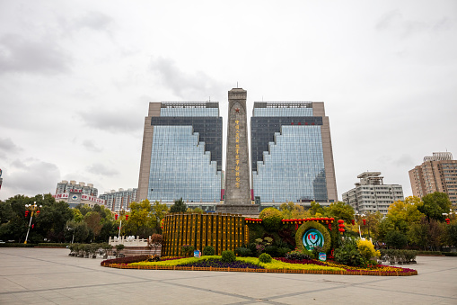 Urumqi, Xinjiang, China- October 13, 2016: Urumqi downtown city square view, business buildings on the road sides and background, incidental people on the background.